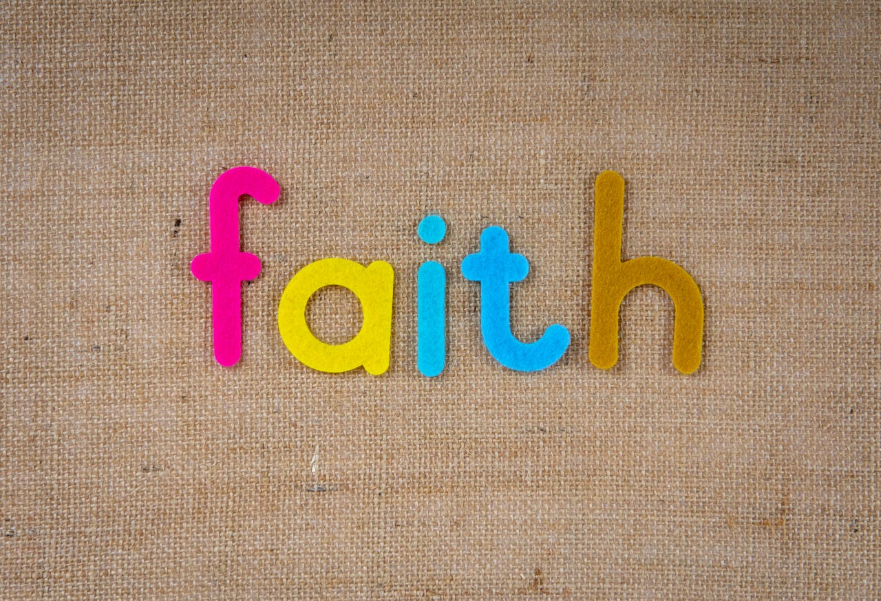Brightly colored text spelling 'faith' on a textured burlap material, conveying spirituality and belief.